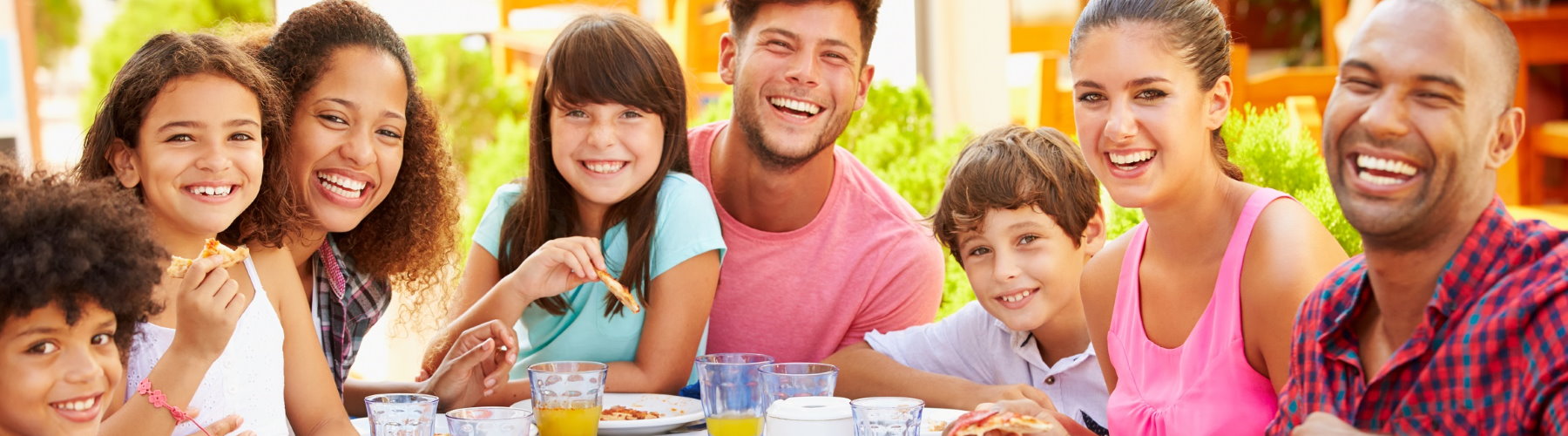 group of friends and children eating and laughing